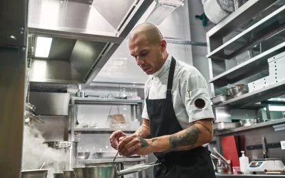 Cozinha equipada com lavadora de louças profissional em funcionamento.