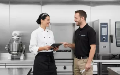 Profissional de cozinha e técnico da Netter conversando em frente a uma lavadoras de louças profissionais em ambiente industrial.